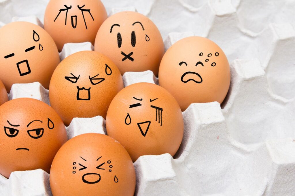 Eggs in carton with different emotions shown as drawing on their 'face'